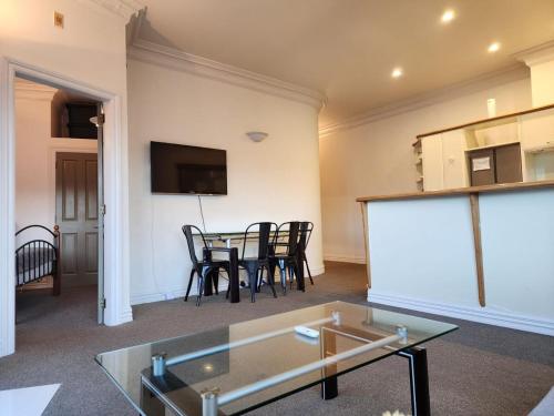 a living room with a glass table and chairs at 2 Bedroom Apartment in Central Wellington in Wellington