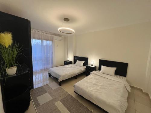 MadinatyProperty Sisters Madinaty, Elite garden view B2的有两张床和一扇窗户的卧室