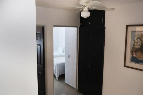 a bedroom with a ceiling fan and a black cabinet at Lomas del Sol in Jarretadera