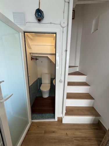 a bathroom with a toilet and a stair case at Casa Farito Muros in Muros