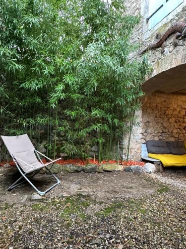 a chair and a mattress in front of a tree at Mazet de Jade in Vallon-Pont-dʼArc