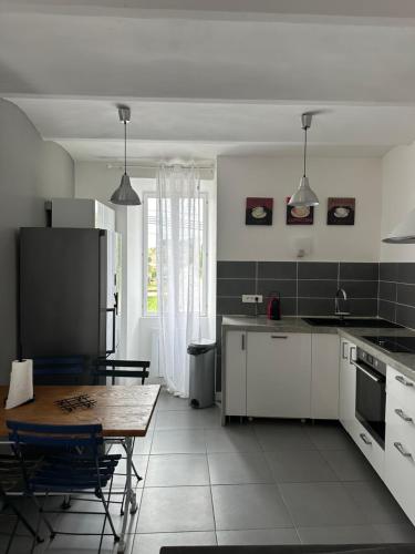 a kitchen with a table and a dining room at Mazet de Jade in Vallon-Pont-dʼArc