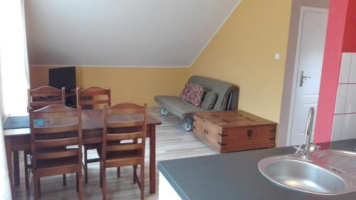 a living room with a table and chairs and a couch at Słoneczna Zagroda - Sunny Ridge Farm in Łączna