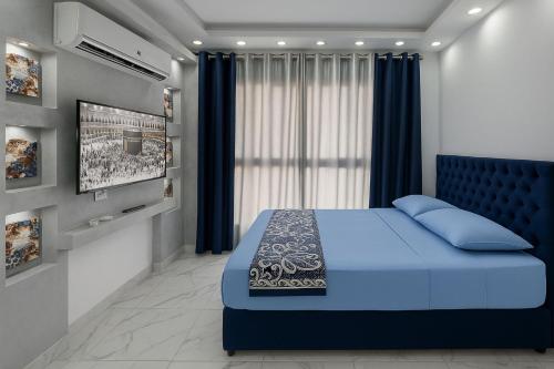 塞得港Unwind in style at Porto Said Chalets by the sea的一间卧室配有蓝色的床和一台平面电视