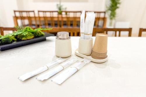 a table with three white utensils on a table at 250平米 ベッド17台 4Bathroom Free Netflix Expo USJへ約10分 in Osaka