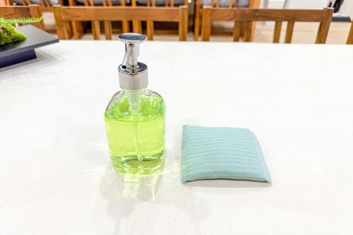 a bottle of liquid sitting on a table with a napkin at 250平米 ベッド17台 4Bathroom Free Netflix Expo USJへ約10分 in Osaka