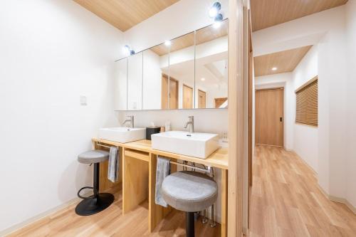 a bathroom with two sinks and a mirror at 250平米 ベッド17台 4Bathroom Free Netflix Expo USJへ約10分 in Osaka