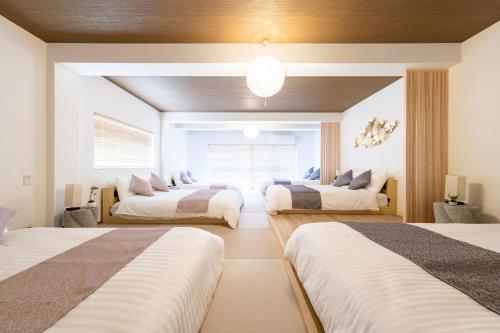 a bedroom with three beds in a room at 250平米 ベッド17台 4Bathroom Free Netflix Expo USJへ約10分 in Osaka