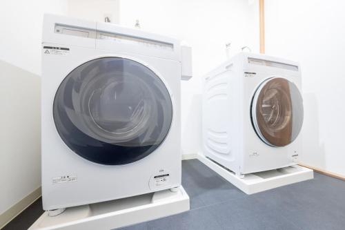 two white washing machines sitting next to each other at 250平米 ベッド17台 4Bathroom Free Netflix Expo USJへ約10分 in Osaka