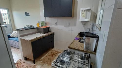 a small kitchen with a sink and a stove at Casa linda e confortável na Penha RJ Próximo ao Ciaa Marinha Cefan Advec Casa do Marinheiro Lespan in Rio de Janeiro
