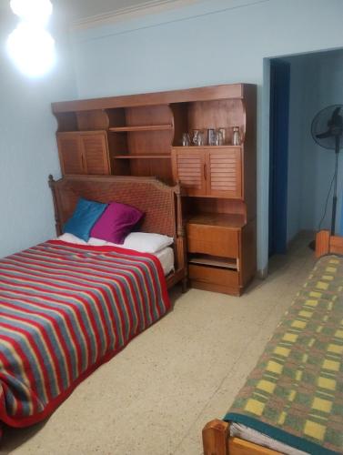 ein Schlafzimmer mit einem Bett mit einem hölzernen Kopfteil in der Unterkunft Departamento zona microcentro in Mar del Plata