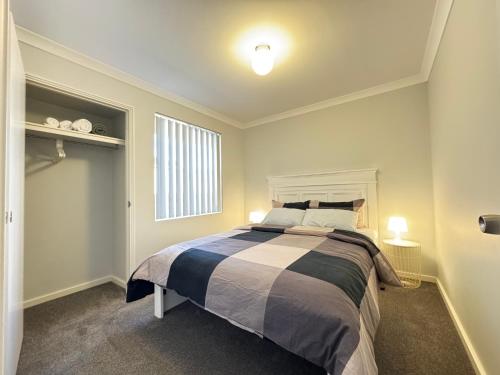 a bedroom with a large bed with two lights on at Blissful Modern Home in Perth
