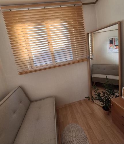 a living room with a couch and a window at Stay Hyuga Suwon in Suwon