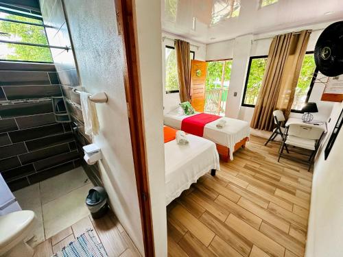 a small room with two beds and a desk at Legoon View in Tortuguero