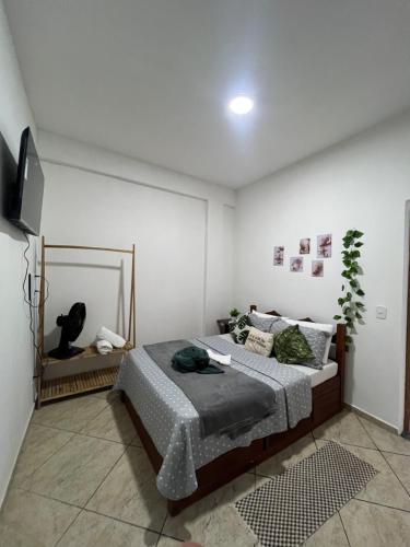a bedroom with a bed and a flat screen tv at Estalagem pé na areia in Arraial do Cabo