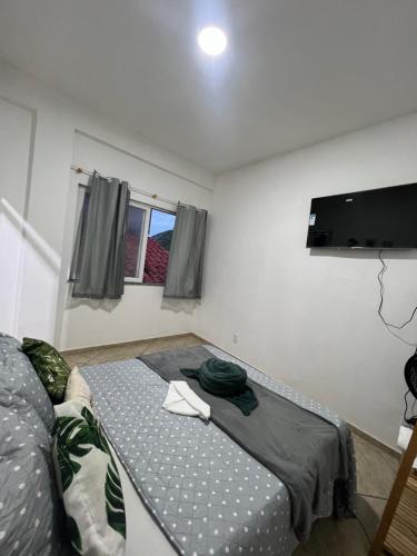 a bedroom with a bed and a flat screen tv at Estalagem pé na areia in Arraial do Cabo