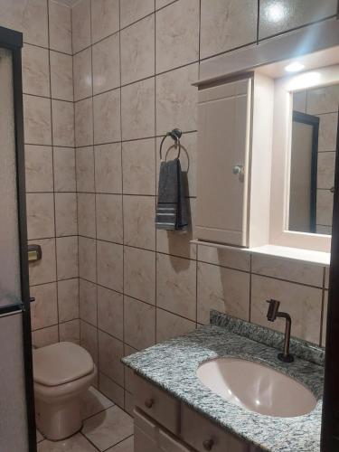 a bathroom with a sink and a toilet and a mirror at Casa térrea aconchegante in Blumenau