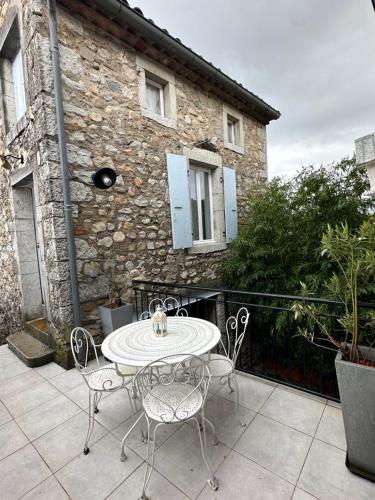 a patio with a table and chairs in front of a building at Mazet de Jade in Vallon-Pont-dʼArc