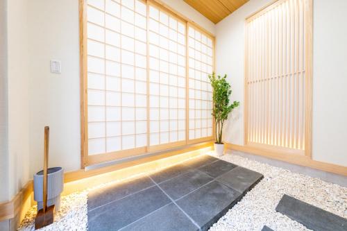 a room with large windows and a potted plant at 250平米 ベッド17台 4Bathroom Free Netflix Expo USJへ約10分 in Osaka
