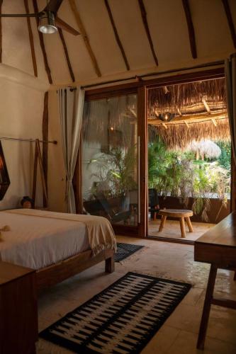 a bedroom with a bed and a sliding glass door at Kasa UhMay Tulum in Francisco Uh May