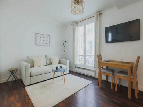 a living room with a couch and a table at Charming studio - 2P- Parc Monceau in Paris