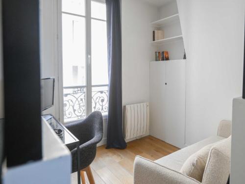 un salon avec un canapé et une fenêtre dans l'établissement Modern Apartment - 2BR-4P- Canal Saint-Martin, à Paris