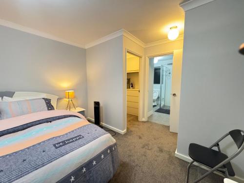 a bedroom with a bed and a chair in it at Blissful Modern Home in Perth