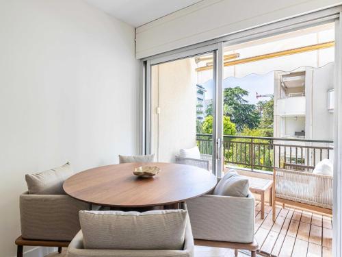 un salon avec une table et des chaises et un balcon dans l'établissement Elegant apartment - AC-4P - Cannes, à Cannes