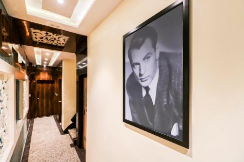 a large black and white picture of a man on a wall at Super Hotel O ABIS INN Hotel Near Dhakuria Manipal Hospital in Kolkata