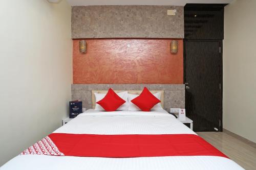 a bedroom with a large bed with red pillows at Super Hotel O ABIS INN Hotel Near Dhakuria Manipal Hospital in Kolkata
