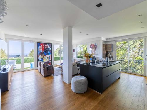 Il comprend une cuisine ouverte et un salon doté de grandes fenêtres. dans l'établissement Modern flat with sea view - AC- 2BR- 4P - Cannes, à Cannes