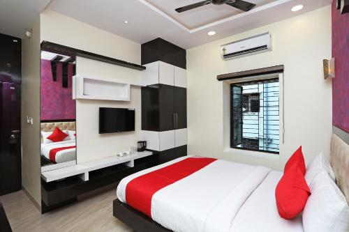 a bedroom with a large bed and a tv at Super Hotel O ABIS INN Hotel Near Dhakuria Manipal Hospital in Kolkata