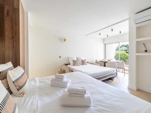- une chambre blanche avec 2 lits et une salle à manger dans l'établissement Elegant apartment - AC-4P - Cannes, à Cannes