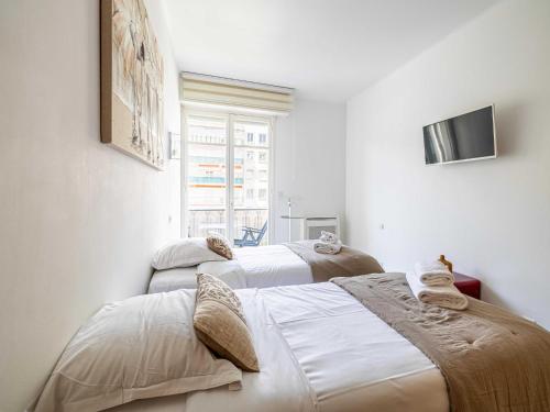 deux lits dans une chambre aux murs blancs dans l'établissement Modern apartment - 2BR-4P- Croisette plage, à Cannes