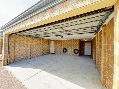 an empty garage with a brick wall at Blissful Modern Home in Perth