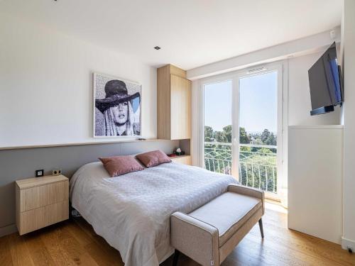 une chambre avec un grand lit et une fenêtre dans l'établissement Modern flat with sea view - AC- 2BR- 4P - Cannes, à Cannes