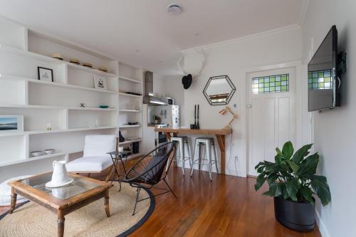 a living room with a table and chairs and a kitchen at Kohimarama Beach 2 Bedroom Charmer in Auckland