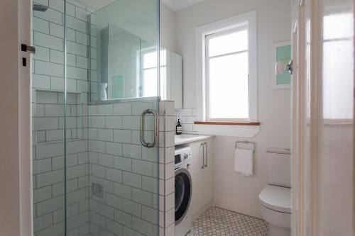 a bathroom with a washing machine in a shower at Kohimarama Beach 2 Bedroom Charmer in Auckland