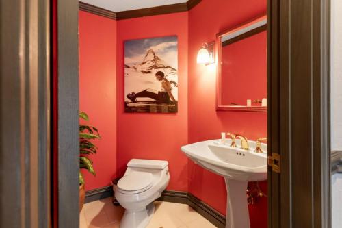a red bathroom with a toilet and a sink at Chic 3 Bedroom Beaver Creek Lodge Residence in Beaver Creek