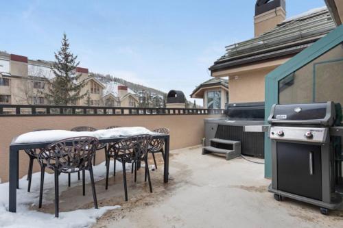 a patio with a table and chairs and a stove at Chic 3 Bedroom Beaver Creek Lodge Residence in Beaver Creek