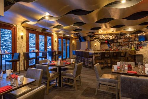 a restaurant with tables and chairs and a bar at Chic 3 Bedroom Beaver Creek Lodge Residence in Beaver Creek