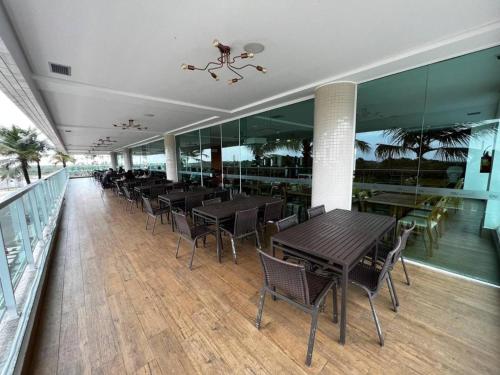 a restaurant with tables and chairs on a balcony at Salinas Premium Resort in Salinópolis