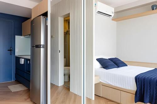 a small bedroom with a bed and a refrigerator at Nik Perdizes in Sao Paulo