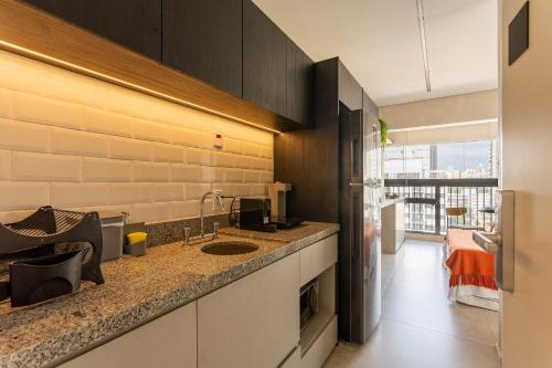 a kitchen with a sink and a counter top at Nik Perdizes in Sao Paulo