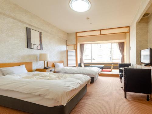 Postel nebo postele na pokoji v ubytování Hotel Ravie Kawaryo
