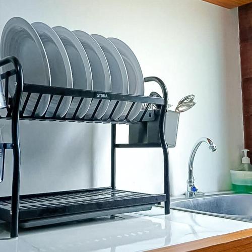 a drying rack on a kitchen counter next to a sink at RedDoorz at Raujan Guesthouse Syariah Banjarmasin in Sungai Lutus