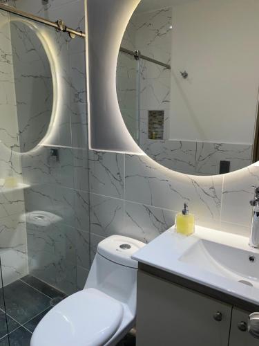 a bathroom with a toilet and a sink and a mirror at Luxury Park 35 in Cali