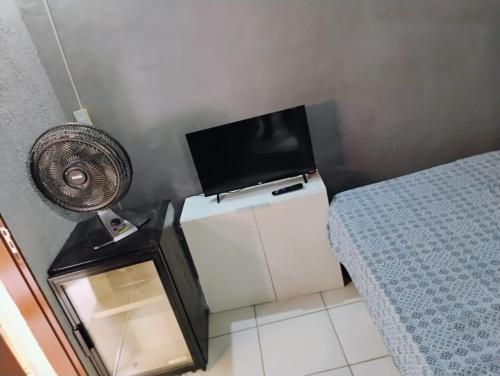 a room with a tv and a bed and a fan at Hostel vila nova in Niterói