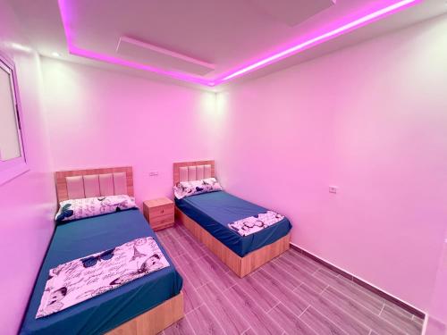 two beds in a room with a pink ceiling at Visit Chamal - Costa Midnight in Oued Laou