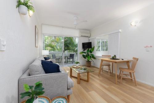 a living room with a couch and a table at Coral Apartments Port Douglas in Port Douglas